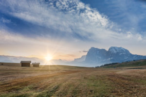 Rising sun in front of Sassolungo / Langkofel and the Sassopiatto / Plattkofel on the Alpe di Siusi / Seiser Alm meadows, Dolomites, Kastelruth, South Tyrol, Italy and on the Alpe di Siusi meadows, Rising sun in front of Sassolungo / Langkofel and the Sassopiatto / Plattkofel on the Alpe di Siusi / Seiser Alm meadows, Dolomites, Kastelruth, South Tyrol, Italy and on the Alpe di Siusi meadows,